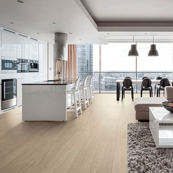 Moderne offene Wohnküche mit hellem Holzoptik Bodenbelag, Kochinsel und integriertem Wohnbereich mit Blick auf eine städtische Skyline.