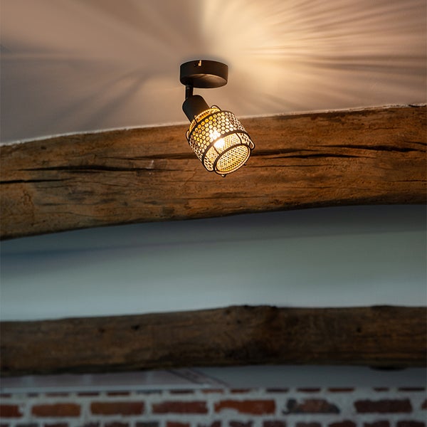 Deckenleuchte mit einem beweglichen Strahler in einem Raum mit Holzbalken