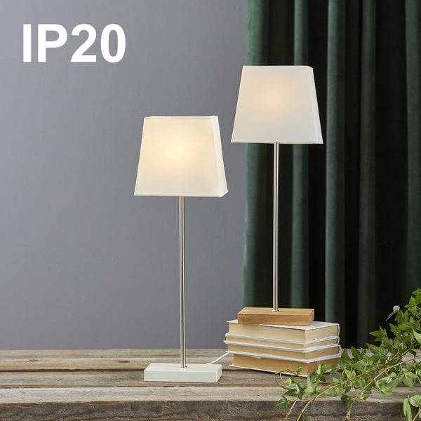 Zwei Tischleuchten mit Stoffschirmen auf einem Stapel Bücher, Schutzart IP20