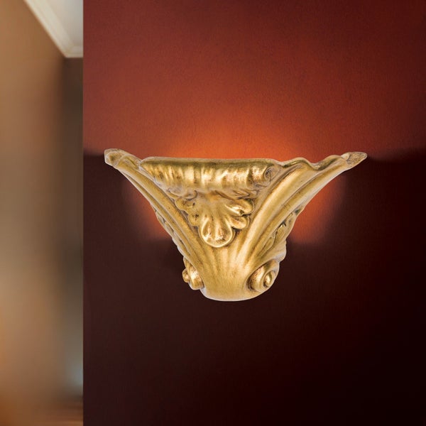 Dekorative Wandleuchte in antiker Goldoptik mit floralen Verzierungen montiert an einer Wand