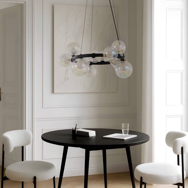 Esszimmer mit einem runden Esstisch, zwei Stühlen und einer modernen Hängeleuchte mit Glaskugeln