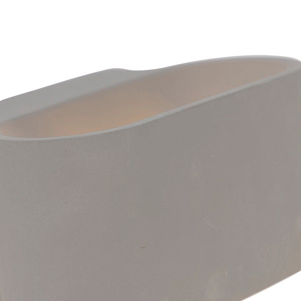 Detailaufnahme einer ovalen Wandleuchte in Betonoptik mit warmem Lichtschein.