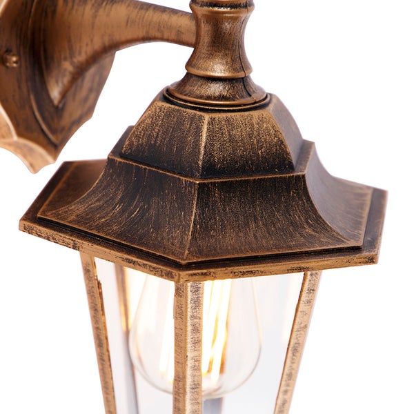 Antike Außenwandleuchte aus Metall in Bronze-Optik mit Klarglas und sichtbarem Leuchtmittel.