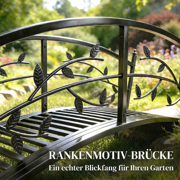 Kleine Gartenbrücke aus Metall mit dekorativen Blattranken am Geländer in einem hellen Garten.