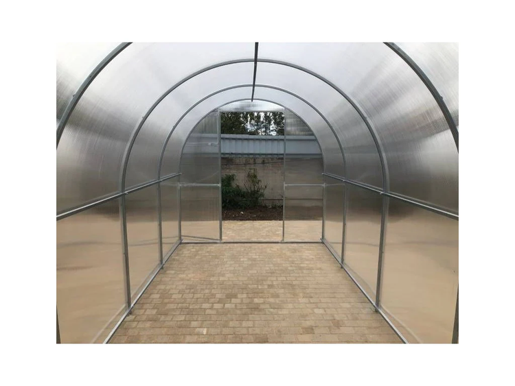 Innenansicht eines Foliengewächshauses mit Pflasterweg