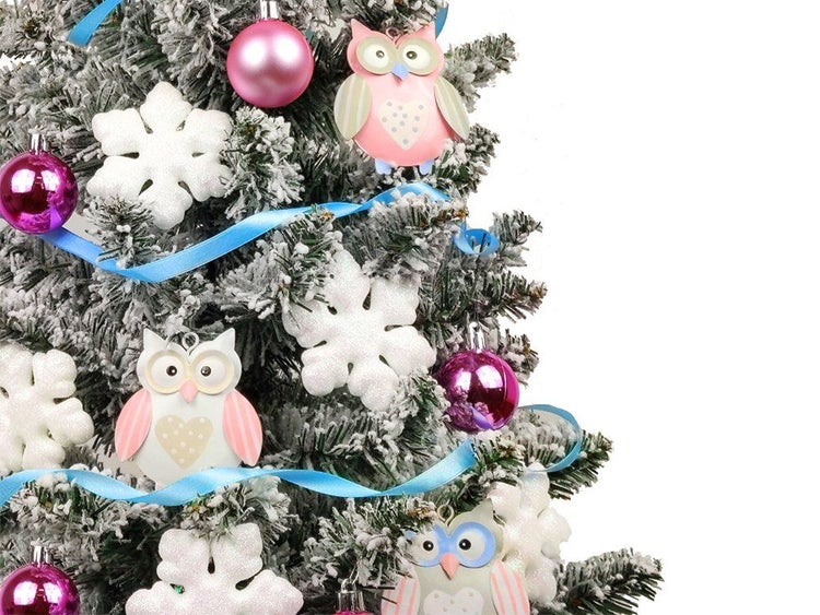 Weihnachtsbaum mit Kunstschnee dekoriert mit Eulenanhängern, glänzenden Weihnachtskugeln, Schneeflocken und einem Schmuckband