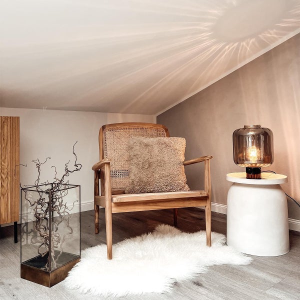 Helle, freundliche Dachgeschosswohnung mit Sessel, Lampe und dekorativen Elementen