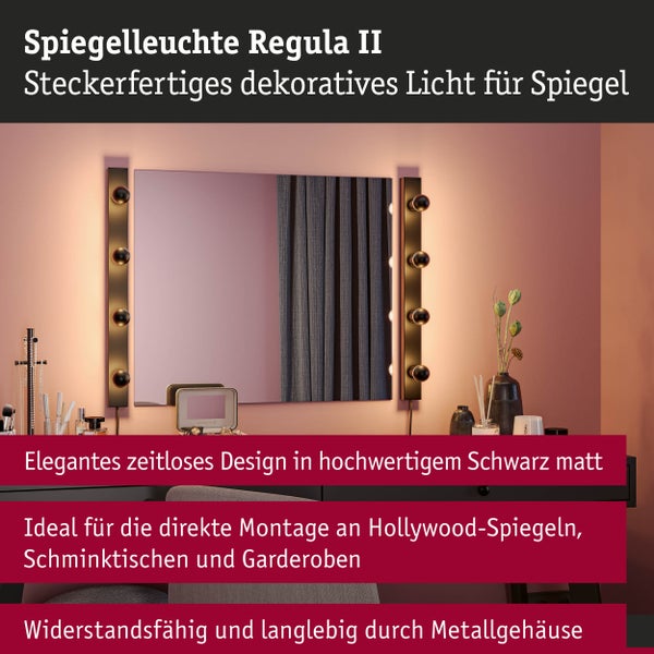 Spiegelleuchte Regula II im Hollywood-Stil, mattschwarze Metallleisten mit runden Lampen neben einem Wandspiegel an einem Schminktisch.