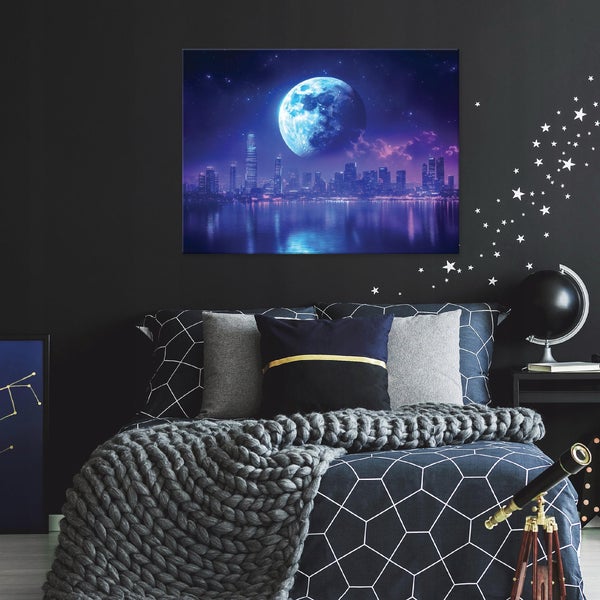 Schlafzimmer mit Bett, Kissen, Decke und einer Wanddekoration mit einem Stadtbild unter einem Mond.