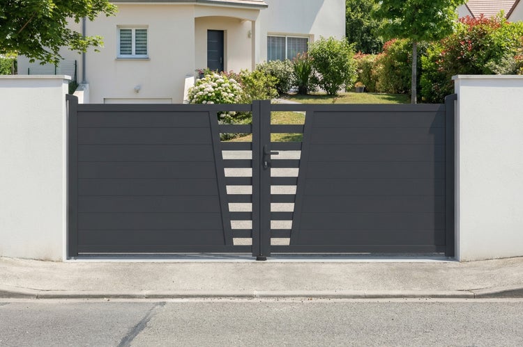Modernes zweiflügeliges Hoftor aus Aluminium in Anthrazit mit horizontalen Lamellen, montiert zwischen zwei weißen Pfeilern vor einem Wohnhaus.