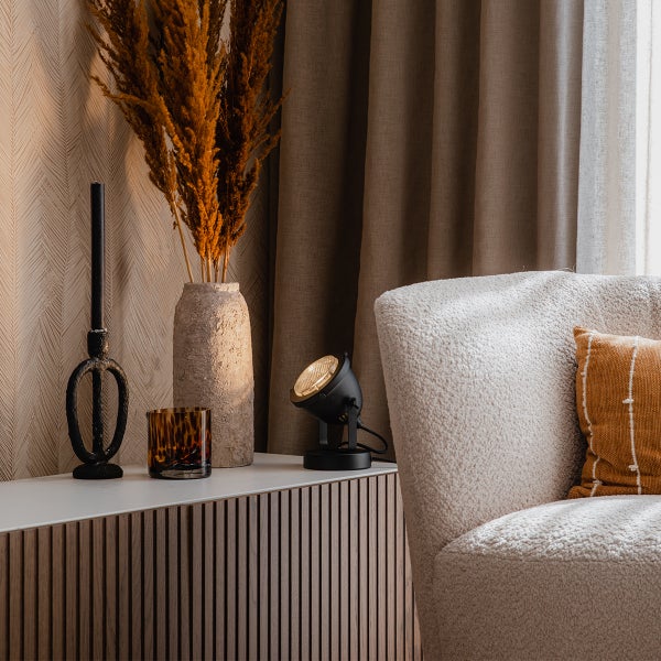 Dekorative Inneneinrichtung mit Leuchte, Kerze, Ziergras und Sessel