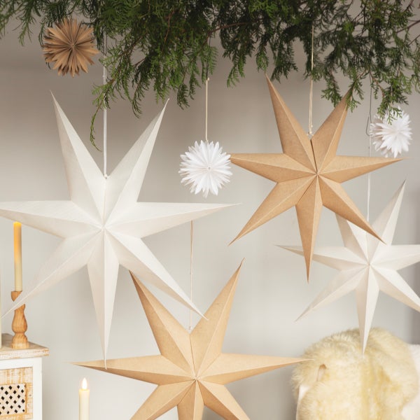 Weihnachtsdekoration mit Papiersternen und Tannenzweigen für festliche Stimmung