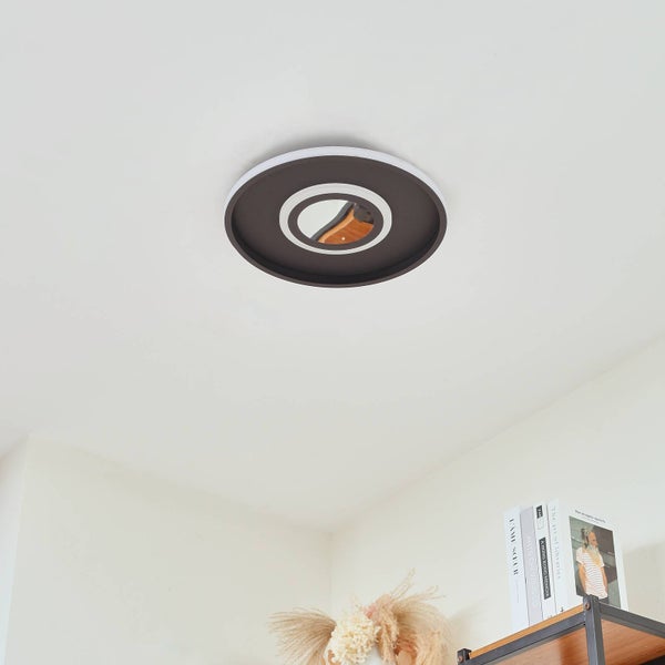 Moderne kreisförmige LED-Deckenleuchte mit ineinander verschachtelten Ringen an einer hellen Zimmerdecke in einem hellen Raum.