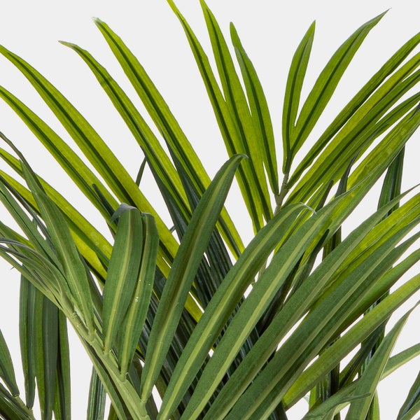Nahaufnahme von grünen künstlichen Palmwedeln einer Kunstpflanze.