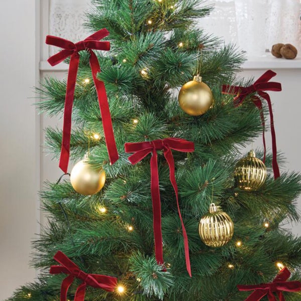 Weihnachtsbaum geschmückt mit Samtschleifen und Weihnachtskugeln
