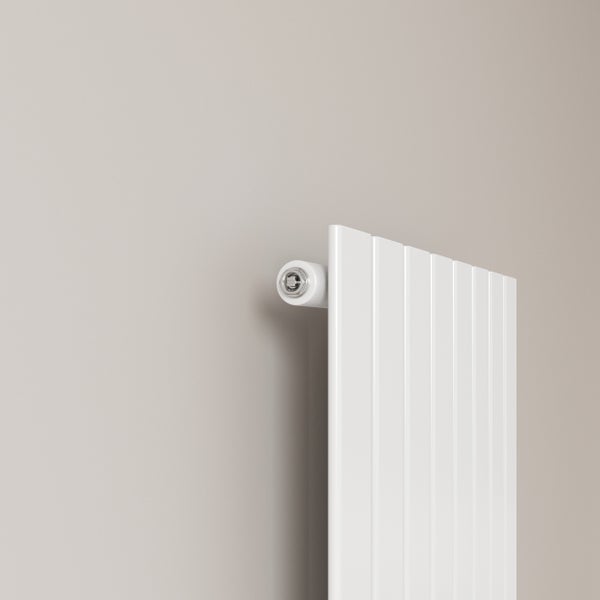 Detailaufnahme eines weißen vertikalen Heizkörpers mit Entlüftungsventil an einer Wand.