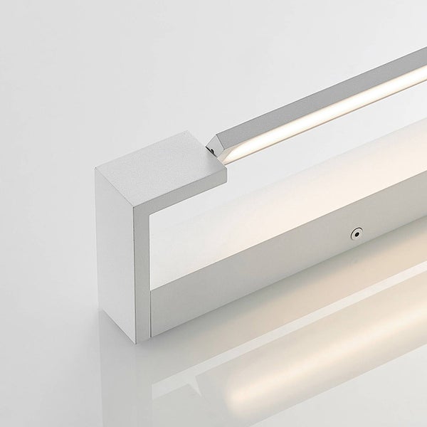Detailansicht einer modernen LED-Wandleuchte aus Metall mit integriertem Leuchtstreifen und warmweißem Licht.
