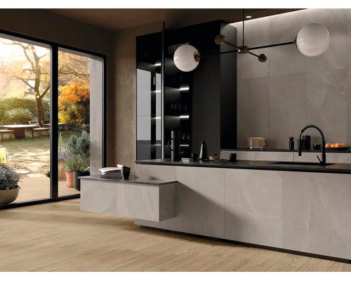 Moderne Küche mit Kochinsel in Steinoptik, Holzfußboden, großer Glasfront zum Garten und minimalistischer Beleuchtung.