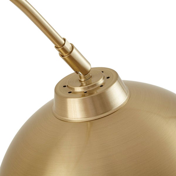 Detailaufnahme einer goldenen Lampe mit Lampenschirm und Befestigung