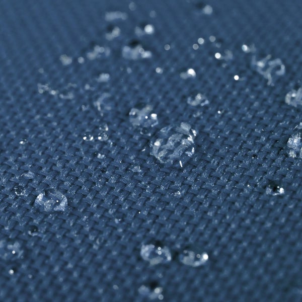 Nahaufnahme eines wasserabweisenden Gewebes mit Wassertropfen auf der Oberfläche.