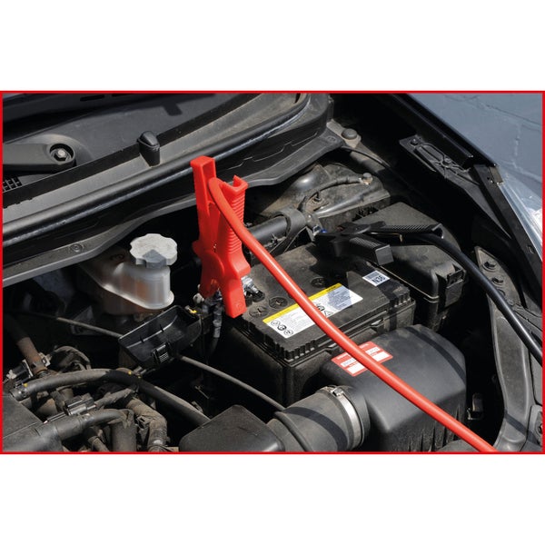 Autobatterie mit Überbrückungskabel im Motorraum