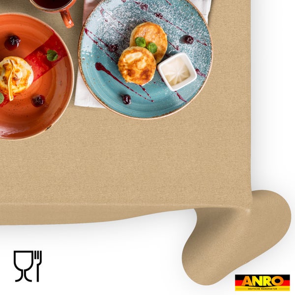 Tischdecke aus Stoff mit Textur auf einem gedeckten Tisch mit Frühstück. ANRO Logo und Symbol für Lebensmittelechtheit.