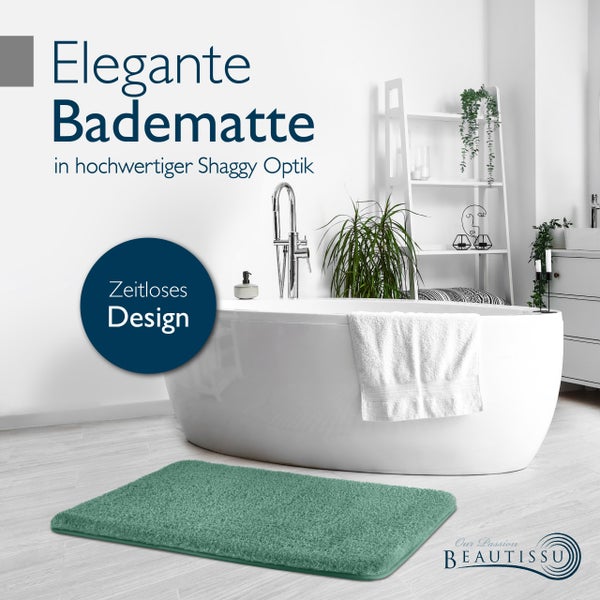 Elegante Badematte mit Shaggy Optik in einem Badezimmer mit Badewanne, Regal und dem Beautissu Logo