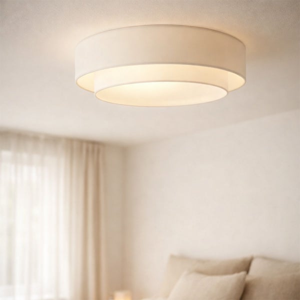 Runde, mehrstufige Deckenleuchte aus Stoff in einem hellen, aufgeräumten Schlafzimmer.
