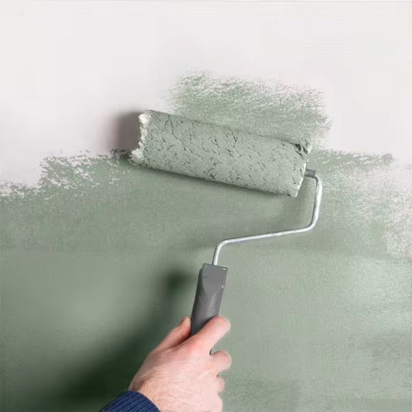 Person streicht Wand mit Farbroller