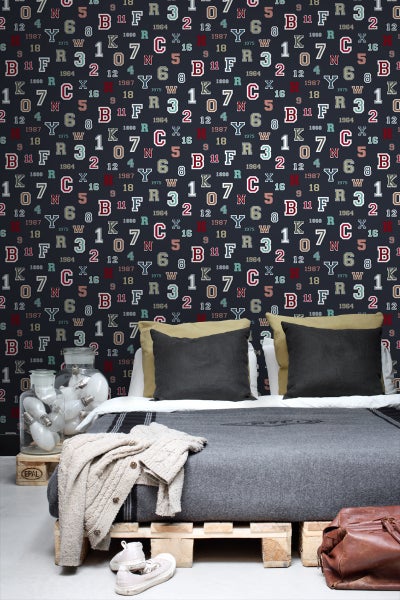 Schlafzimmer mit gemusterter Tapete, Bett auf Europaletten und dekorativen Elementen