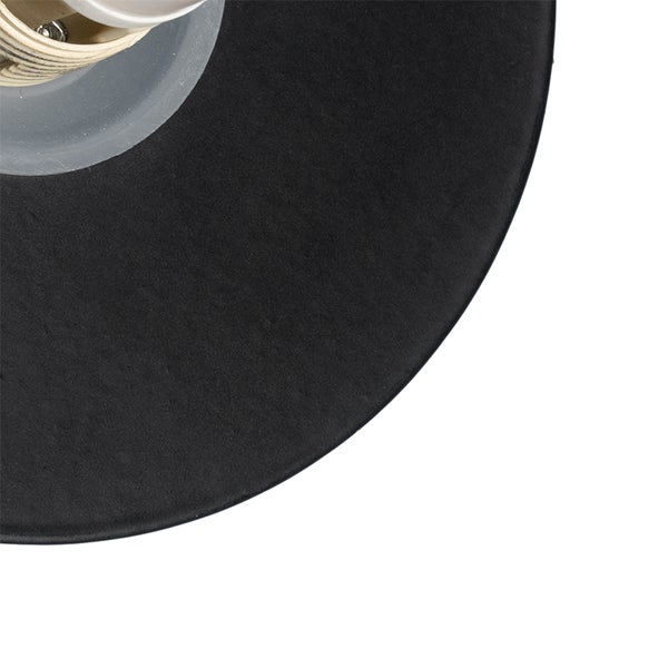 Wandleuchte neben dekorativen Elementen an einer dunklen Wand