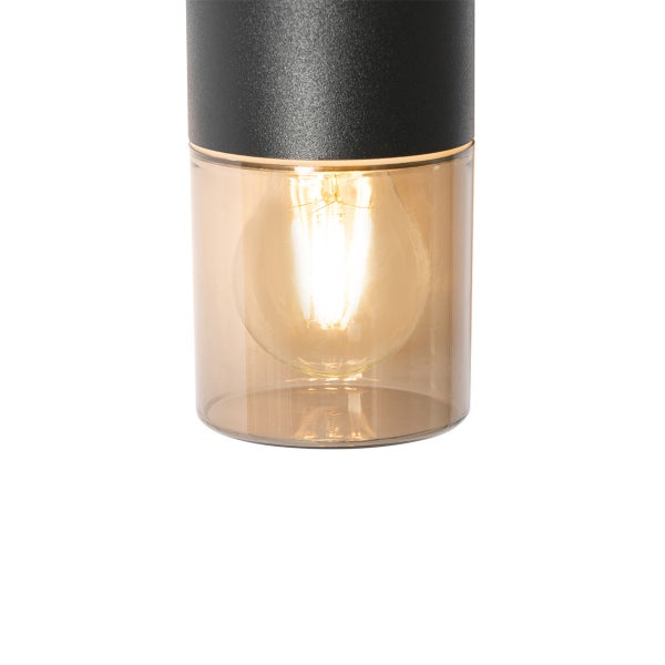 Detailaufnahme einer Außenleuchte mit schwarzem Metallgehäuse, getöntem Glaszylinder und brennendem LED Filament Leuchtmittel.