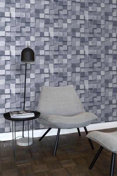 Wohnzimmer mit Relief-Tapete in Holzoptik, Sessel, Beistelltisch und Stehlampe.