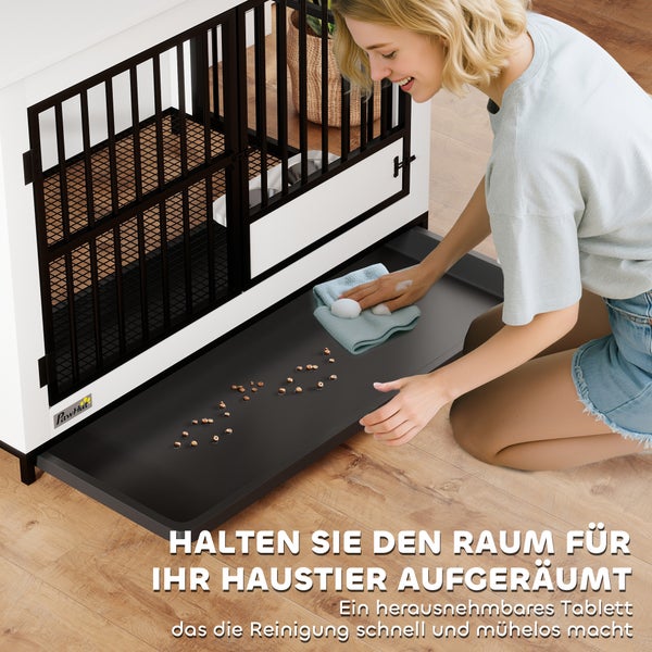 Eine Frau reinigt die herausnehmbare Bodenwanne einer PawHut Hundebox aus Holz und Metall auf einem Holzboden. Modernes Design, PawHut Logo.
