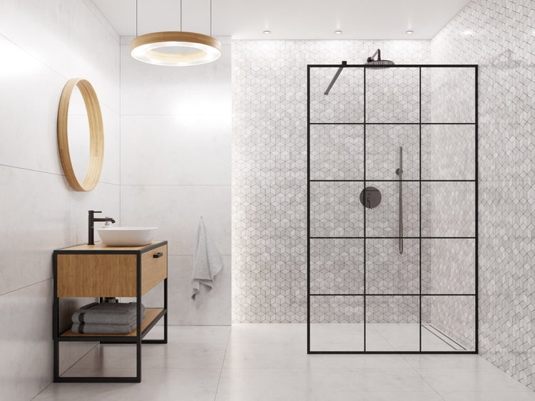 Modernes Badezimmer mit begehbarer Dusche mit schwarzer Glasabtrennung im Sprossendesign, Holz-Waschtischunterschrank und rundem Spiegel.