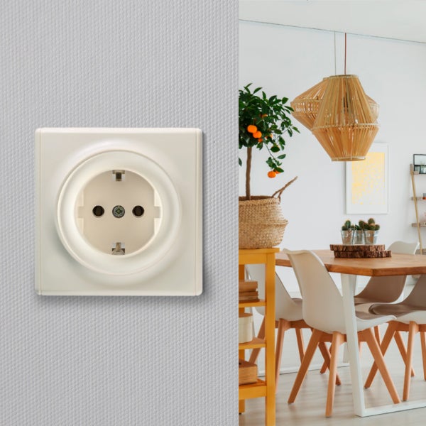 Eine Schuko Steckdose installiert auf einer strukturierten Wand mit einem modernen Esszimmer im Hintergrund.