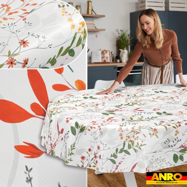 Runde Tischdecke mit floralem Muster aus Wildblumen und Blättern in einer hellen, modernen Küche mit ANRO Logo.