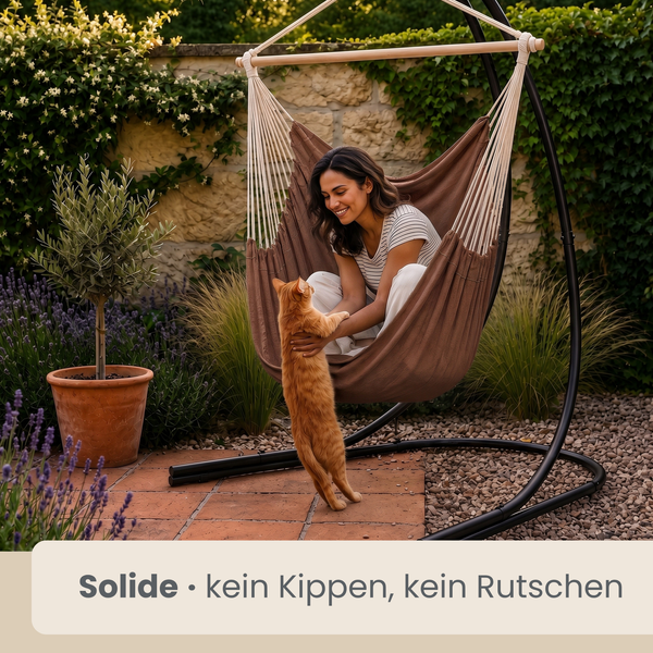 Frau sitzt in einem stabilen Hängesessel mit Gestell im Garten und spielt mit einer Katze. Der Sessel steht fest auf einer Terrasse.