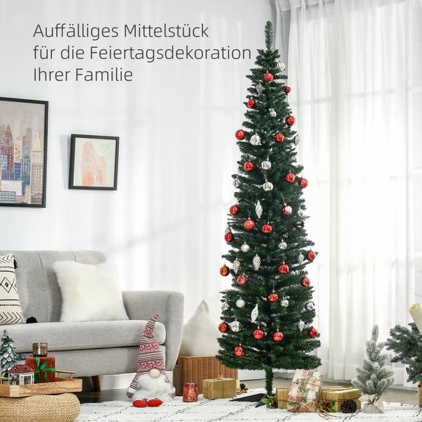 Schmaler künstlicher Weihnachtsbaum in einem hellen Wohnzimmer, dekoriert mit roten und silbernen Kugeln, neben einem Sofa und Geschenken.