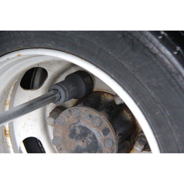 Ein Mann wechselt mit einem Drehmomentschlüssel ein Rad an einem Fahrzeug.