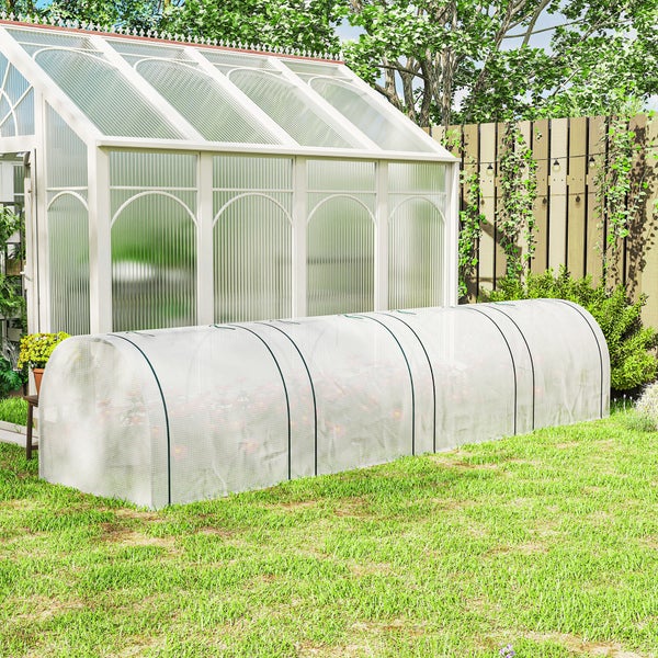Folientunnel als Anzuchthaus im Garten vor einem Gewächshaus auf einer Rasenfläche