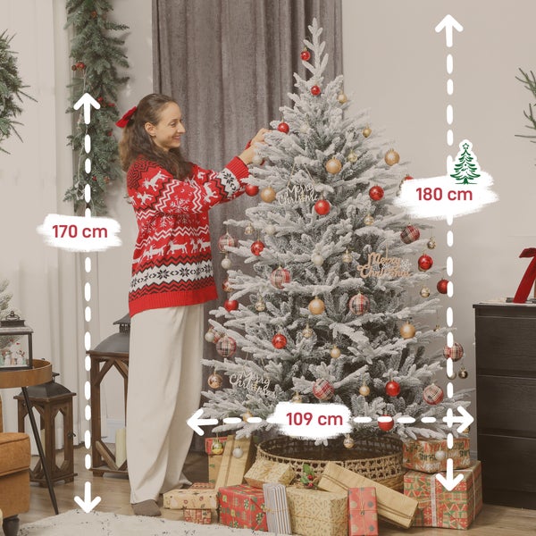 Eine Frau dekoriert einen künstlichen, schneebedeckten Weihnachtsbaum mit einer Höhe von 180 Zentimetern und einer Breite von 109 Zentimetern.