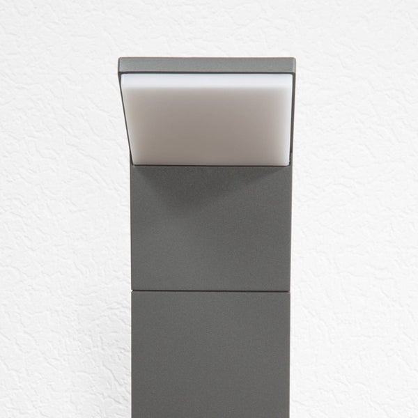 Moderne LED-Außenleuchte in Anthrazit mit weißem Kunststoffdiffusor vor einer strukturierten Wand.