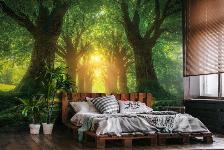 Schlafzimmer mit Fototapete eines grünen Waldes und einem Palettenbett