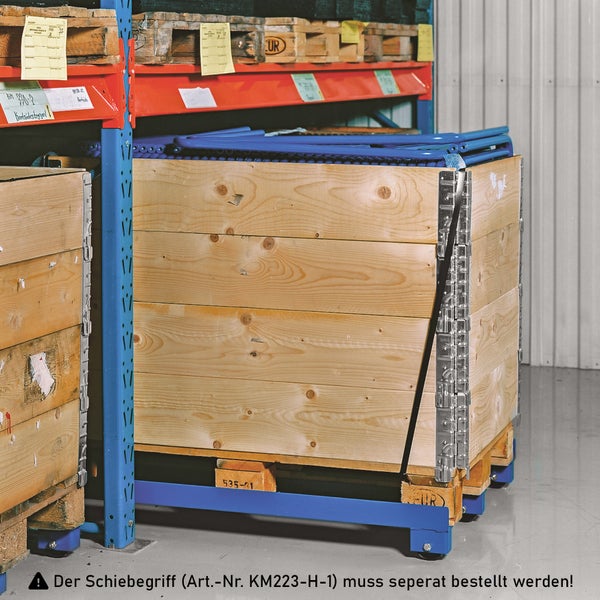 Holzkiste mit blauen Metallbeschlägen auf einer Lagerpalette im Lagerregal