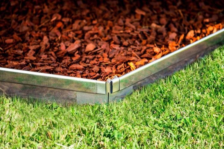 Beetumrandung aus Metall mit Rindenmulch und Rasen