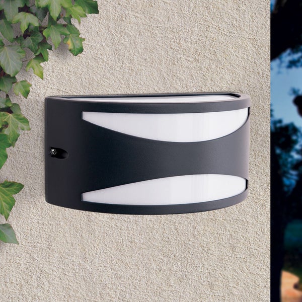 Moderne schwarze LED-Außenwandleuchte mit zwei bogenförmigen weißen Lichtaustritten an einer strukturierten Hauswand.