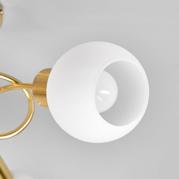 Wandleuchte mit weißem kugelförmigem Glasschirm und messingfarbenem Metallarm, Detailansicht der Leuchte.