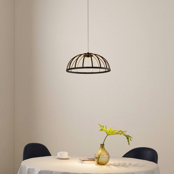 Moderne schwarze LED-Pendelleuchte in Käfigoptik, hängend über einem runden Esstisch in einem hellen, minimalistischen Raum.