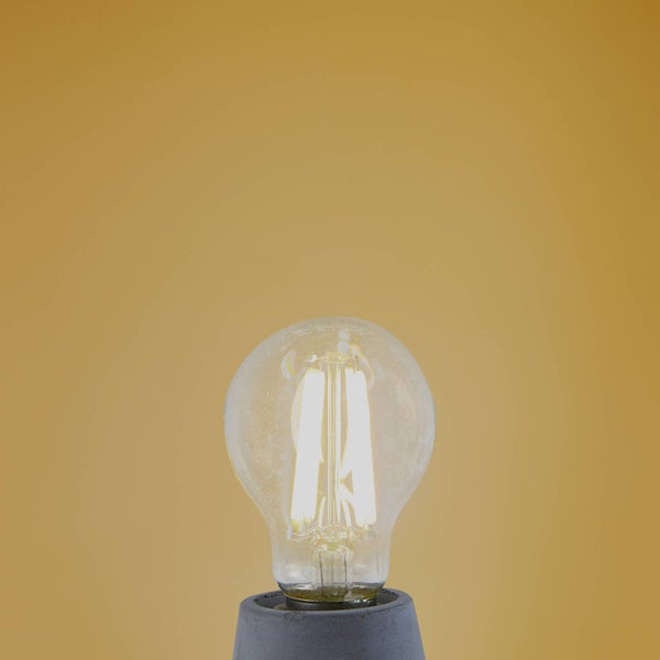 Leuchtendes LED-Leuchtmittel in klassischer Kolbenform mit Filament-Technik in einer Fassung.